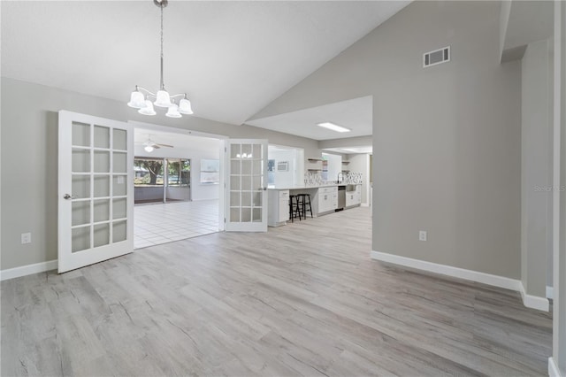 3240 Flamingo Ln, Mulberry, FL 33860 - unfurnished living room featuring french doors, a chandelier, light wood finished floors, and high vaulted ceiling