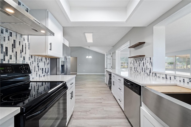 3240 Flamingo Ln, Mulberry, FL 33860 - kitchen featuring appliances with stainless steel finishes, wall chimney exhaust hood, decorative backsplash, open shelves, and vaulted ceiling