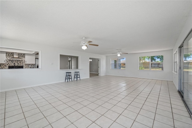 3240 Flamingo Ln, Mulberry, FL 33860 - unfurnished living room featuring a ceiling fan, a textured ceiling, and light tile patterned floors