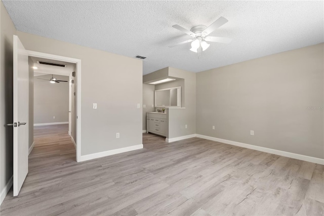 3240 Flamingo Ln, Mulberry, FL 33860 - unfurnished bedroom with light wood finished floors, a textured ceiling, ensuite bathroom, and a ceiling fan