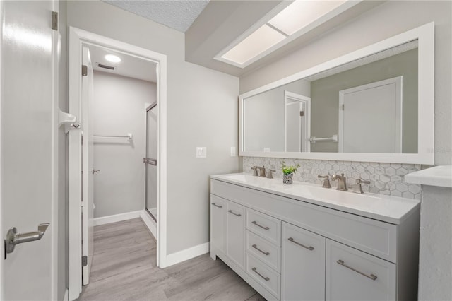 3240 Flamingo Ln, Mulberry, FL 33860 - bathroom featuring decorative backsplash, double vanity, wood finished floors, and a stall shower