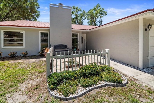 3240 Flamingo Ln, Mulberry, FL 33860 - back of house featuring a chimney, stucco siding, and a metal roof