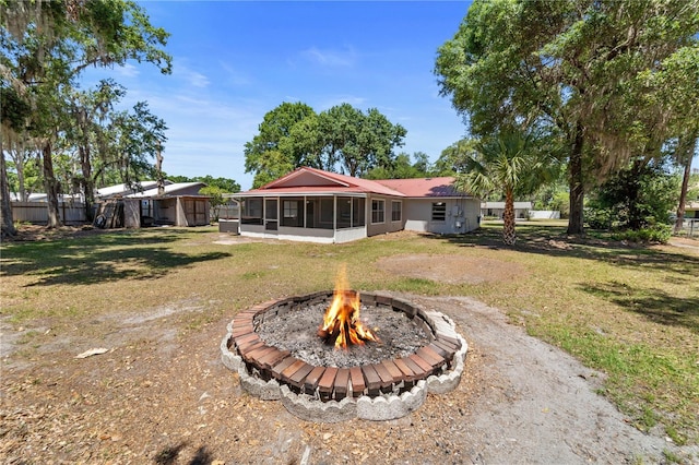 3240 Flamingo Ln, Mulberry, FL 33860 - rear view of property featuring a sunroom and a fire pit
