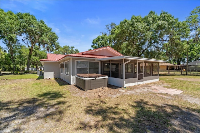 3240 Flamingo Ln, Mulberry, FL 33860 - back of property with a sunroom, a metal roof, and a hot tub