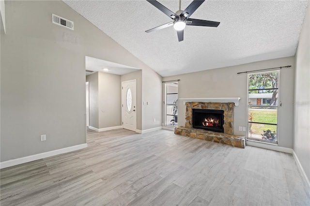 3240 Flamingo Ln, Mulberry, FL 33860 - unfurnished living room with a textured ceiling, wood finished floors, ceiling fan, a fireplace, and vaulted ceiling