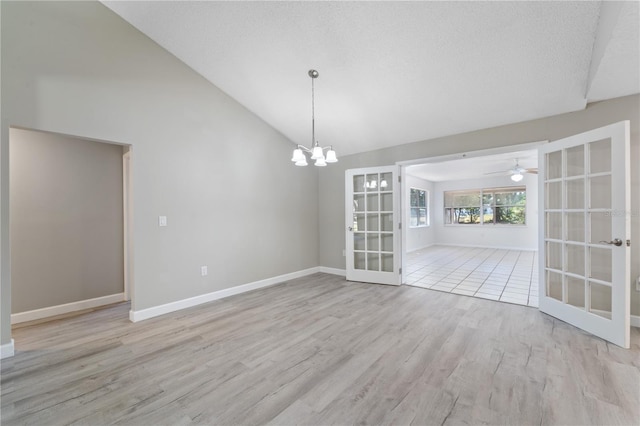 3240 Flamingo Ln, Mulberry, FL 33860 - unfurnished dining area with french doors, wood finished floors, a chandelier, high vaulted ceiling, and a ceiling fan