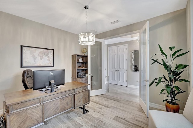 office with an inviting chandelier and light hardwood / wood-style flooring