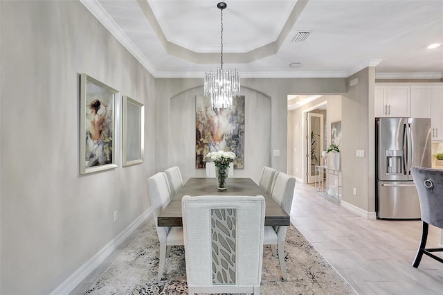 dining room featuring ornamental molding, a chandelier, and a tray ceiling