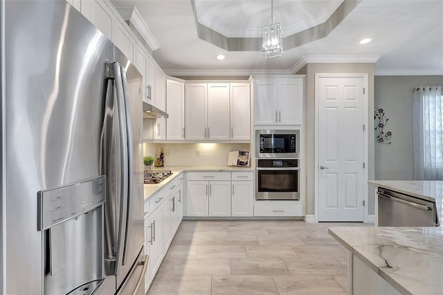 kitchen with white cabinets, light stone countertops, stainless steel appliances, and crown molding