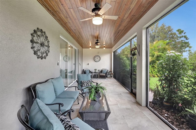 sunroom featuring wood ceiling and ceiling fan