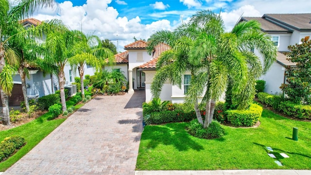 mediterranean / spanish-style home with a front lawn and central AC