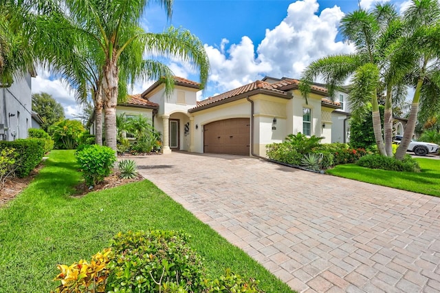 mediterranean / spanish home with a garage and a front yard