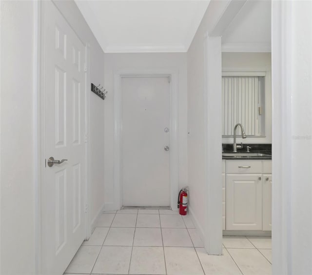 interior space with ornamental molding, sink, and light tile patterned floors