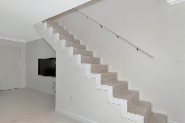 stairs with carpet floors and ornamental molding