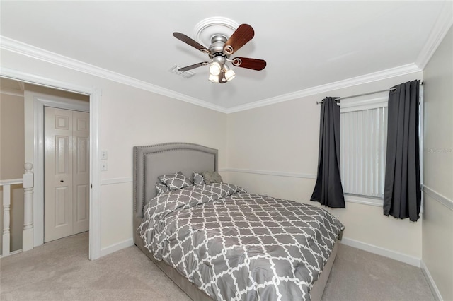 carpeted bedroom with crown molding, ceiling fan, and a closet