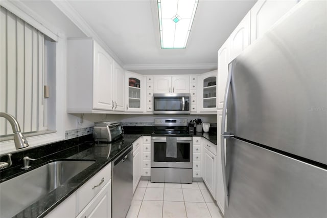 kitchen with stainless steel appliances, sink, dark stone countertops, and white cabinets