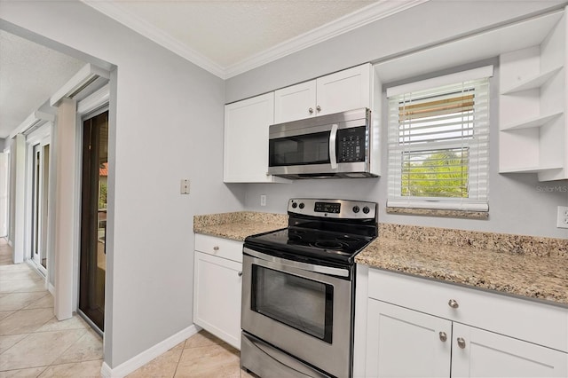 kitchen featuring light stone countertops, white cabinetry, stainless steel appliances, light tile patterned flooring, and ornamental molding