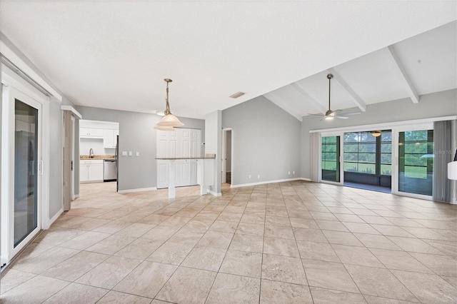 tiled empty room with lofted ceiling with beams, ceiling fan, and sink