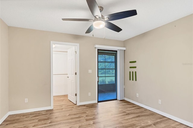 spare room featuring ceiling fan, light hardwood / wood-style flooring, and a textured ceiling