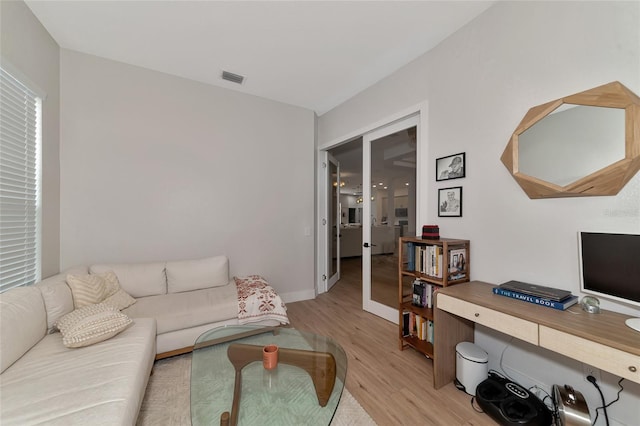 living room with light hardwood / wood-style flooring and french doors