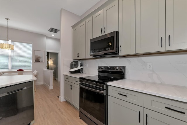 kitchen featuring black appliances, tasteful backsplash, light hardwood / wood-style floors, gray cabinets, and light stone counters