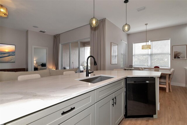 kitchen with black dishwasher, light hardwood / wood-style flooring, sink, and a healthy amount of sunlight