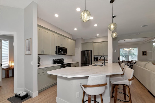 kitchen with gray cabinetry, light hardwood / wood-style flooring, stainless steel appliances, sink, and decorative backsplash