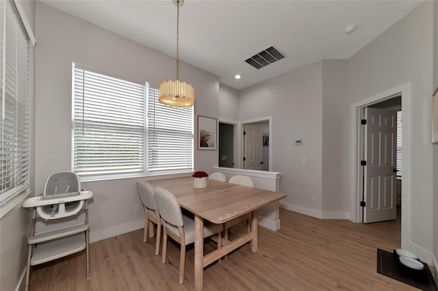 dining area featuring light hardwood / wood-style floors and a notable chandelier