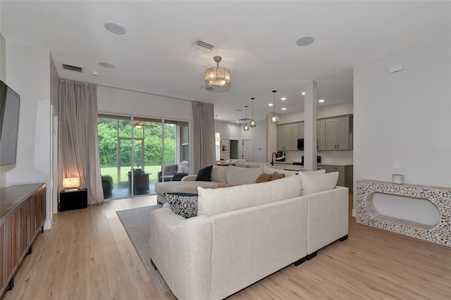 living room with light hardwood / wood-style flooring and a chandelier