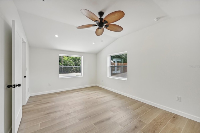 spare room with vaulted ceiling, light hardwood / wood-style flooring, and ceiling fan