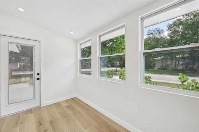 entryway with plenty of natural light, light hardwood / wood-style floors, and lofted ceiling