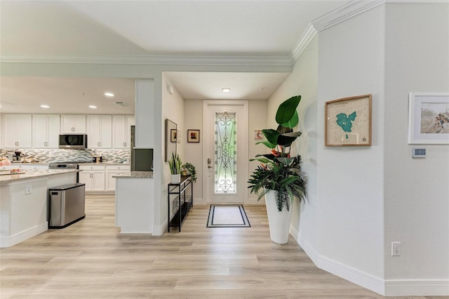 foyer entrance with crown molding and light wood-type flooring