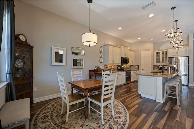 dining area with dark hardwood / wood-style floors, a chandelier, and sink