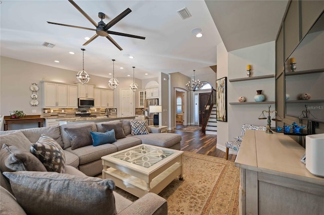 living room with ceiling fan with notable chandelier and wood-type flooring