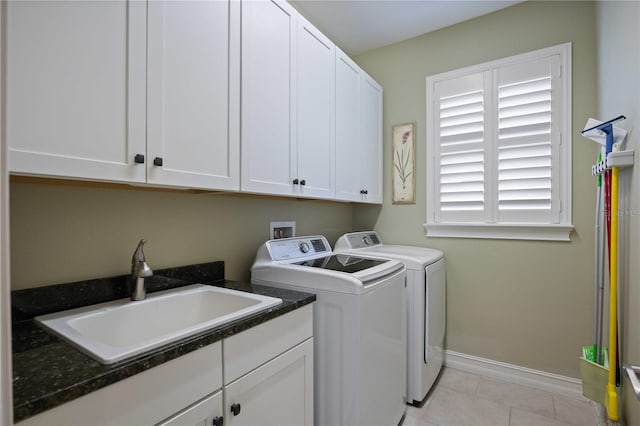 laundry area featuring cabinets, light tile patterned floors, washer and clothes dryer, and sink