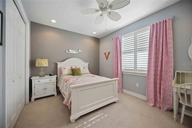 carpeted bedroom featuring ceiling fan and a closet