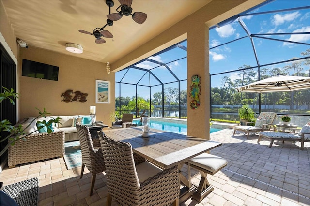 view of patio with a water view, an outdoor living space, a lanai, and ceiling fan