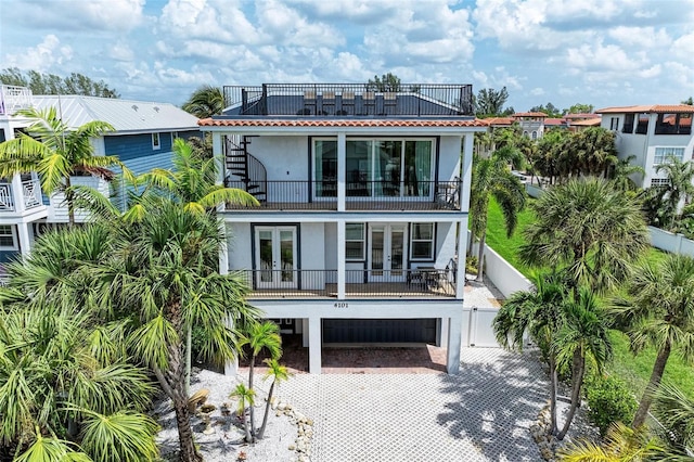 back of property with a balcony and a garage