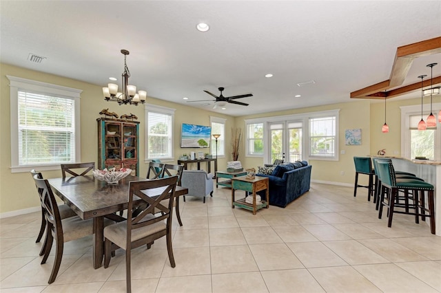 tiled dining room with ceiling fan with notable chandelier