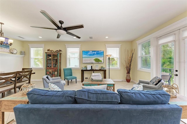 living room with light tile patterned floors, ceiling fan, and a wealth of natural light