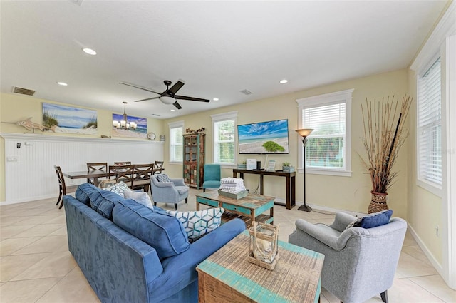 living room with ceiling fan with notable chandelier and light tile patterned floors