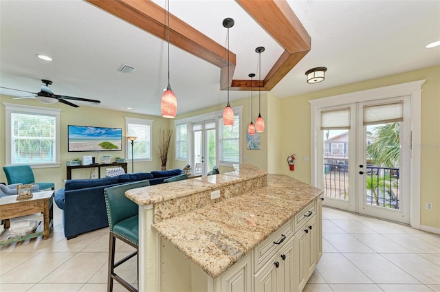 kitchen with decorative light fixtures, light stone countertops, ceiling fan, and french doors