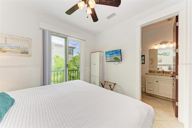 bedroom featuring ensuite bathroom, sink, access to outside, light tile patterned flooring, and ceiling fan