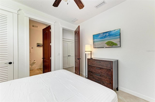 tiled bedroom with ensuite bath, a textured ceiling, and ceiling fan