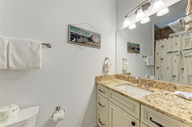 bathroom featuring vanity, toilet, and walk in shower