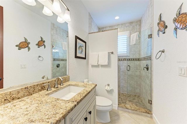 bathroom with tile patterned floors, vanity, toilet, and a shower with shower door