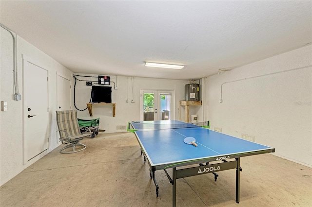 playroom with french doors, water heater, and concrete flooring