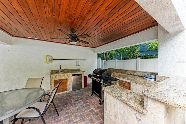 view of patio with a grill, an outdoor kitchen, sink, and ceiling fan