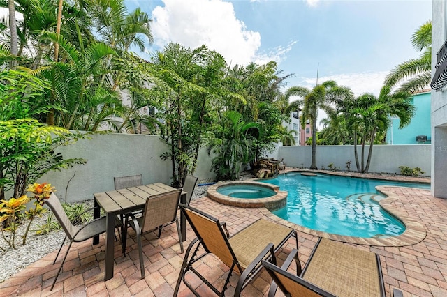 view of pool featuring a patio area and an in ground hot tub