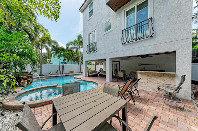 view of pool featuring an outdoor living space, pool water feature, an in ground hot tub, ceiling fan, and a patio